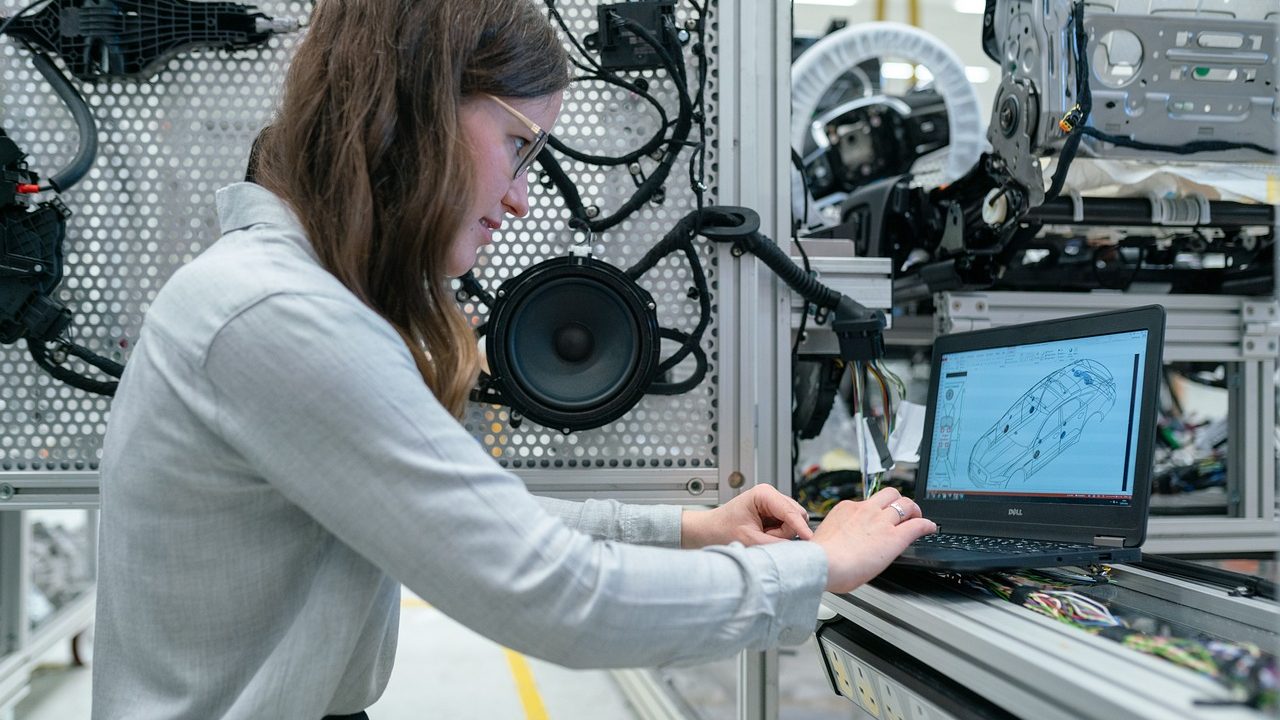 Robotic arms working on an automotive assembly line in a large factory.