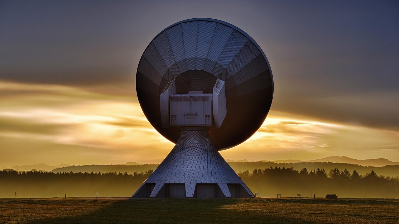 Large white satellite dish antennas pointed at the sky.