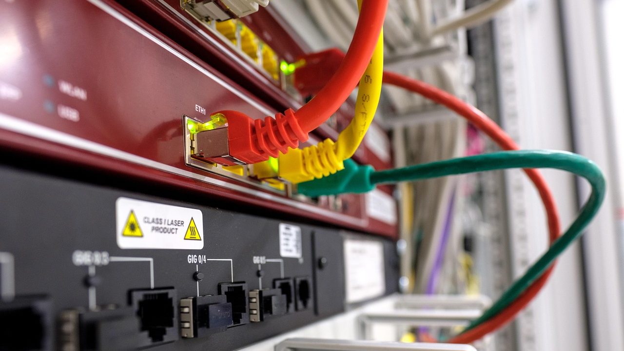 A close-up of a network router with blinking LED indicator lights.