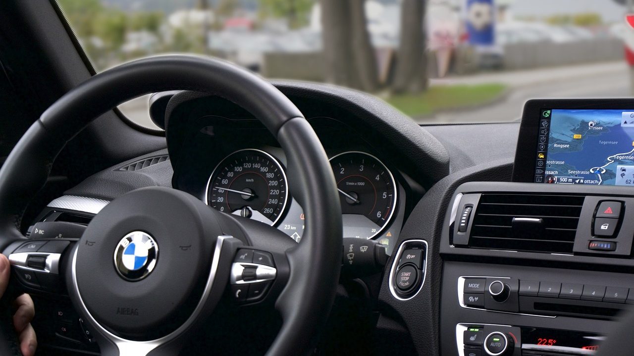 A close-up of a camera sensor mounted on a vehicle dashboard above the steering wheel.