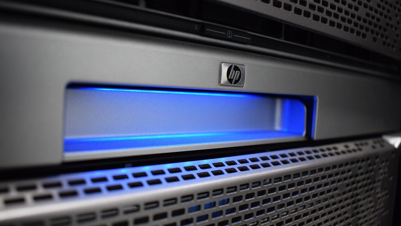 Close-up of cable connections and indicator lights on a network rack in a server room.