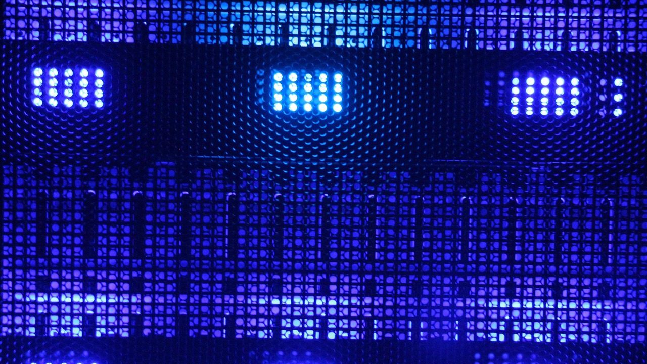 A computer monitor displaying financial dashboard charts and data in a dimly lit office.