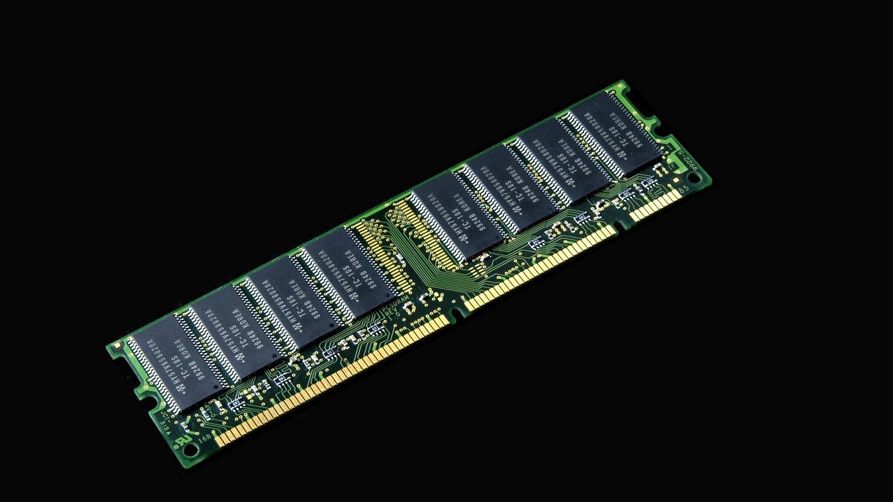 A vintage microprocessor chip resting on a wooden surface with visible gold pin connectors.