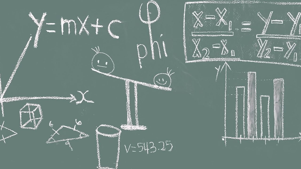 A chalkboard covered in dense mathematical equations and diagrams.