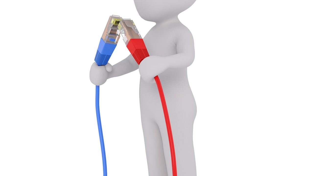 Colorful ethernet cables connect to a server rack in a network closet.