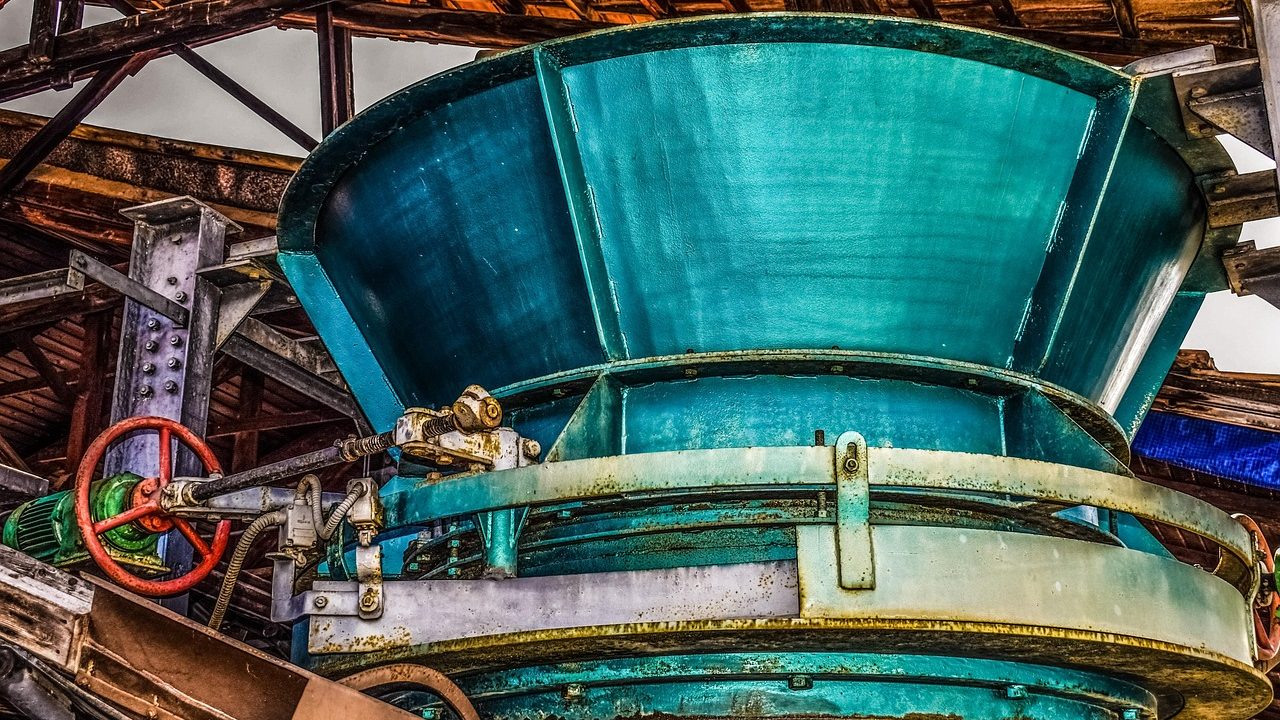 Vintage industrial machinery with large gears and iron framework in a historic factory.