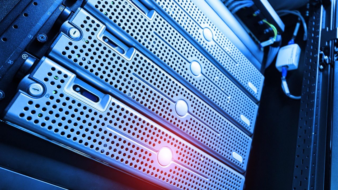 Rows of illuminated server racks inside a large data center facility.