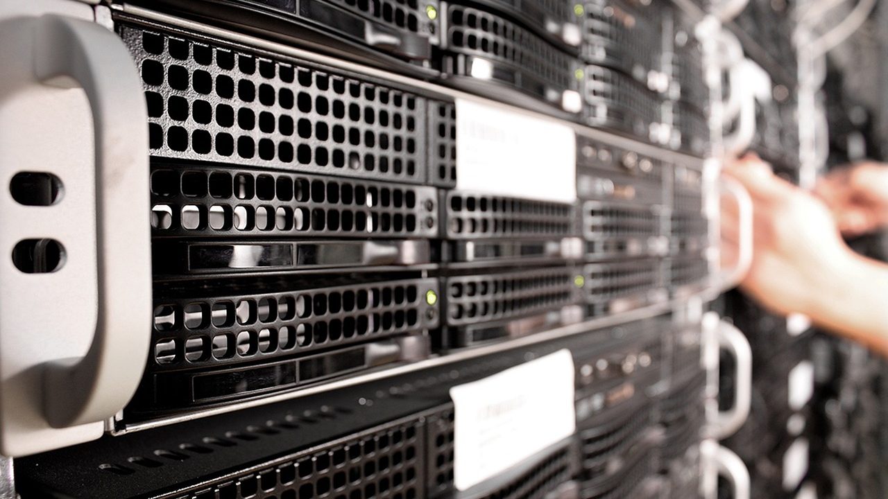 Rows of illuminated server racks inside a modern data center facility.