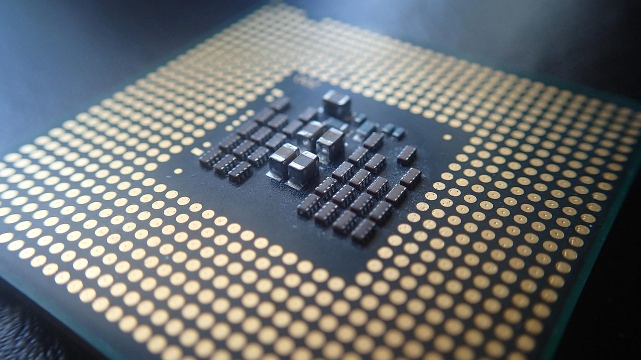 A silicon wafer with dozens of microchip dies arranged in a grid under clean-room lighting.