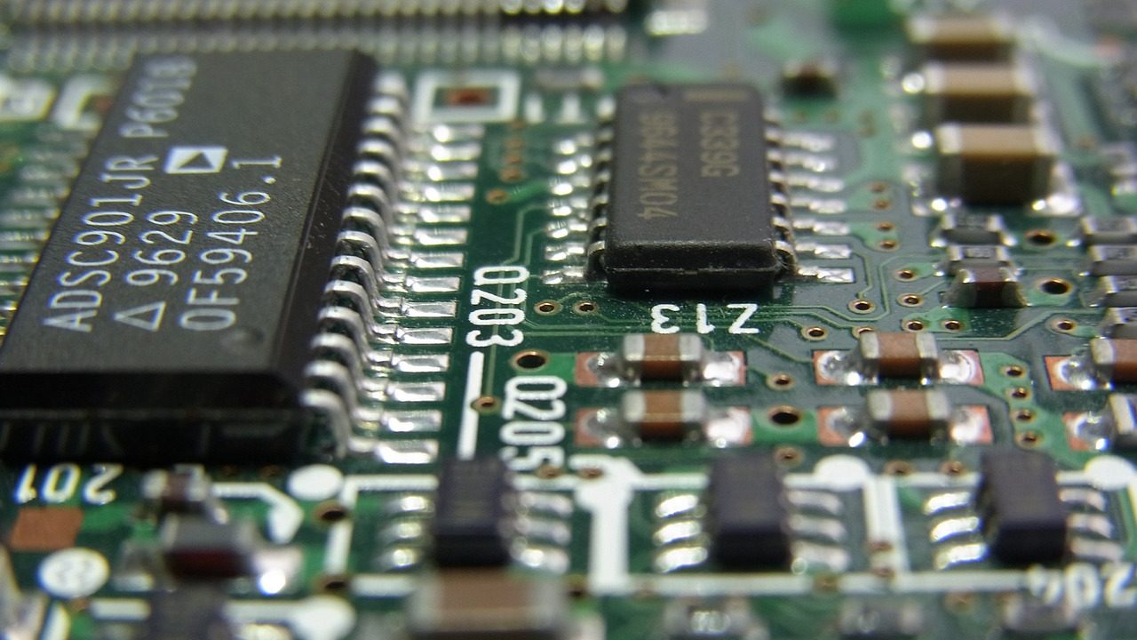 An extreme close-up of a green printed circuit board showing soldered components and copper traces.