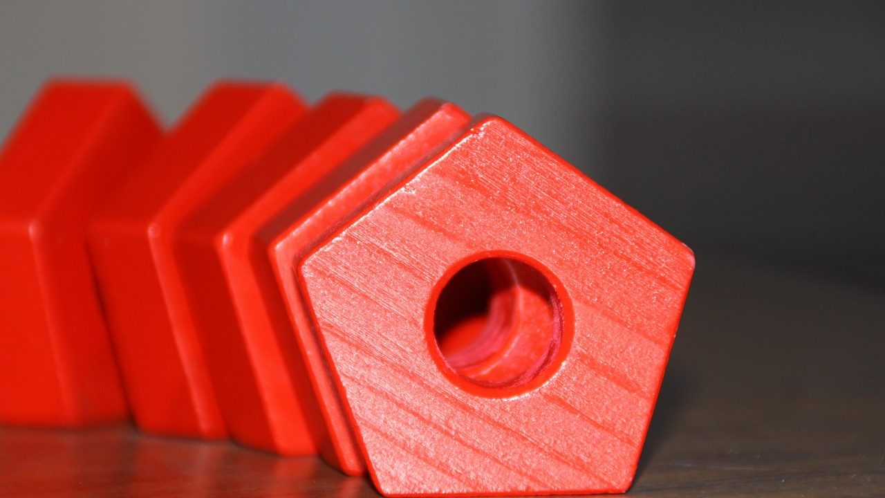 Colorful geometric puzzle blocks arranged in abstract patterns on a white surface.