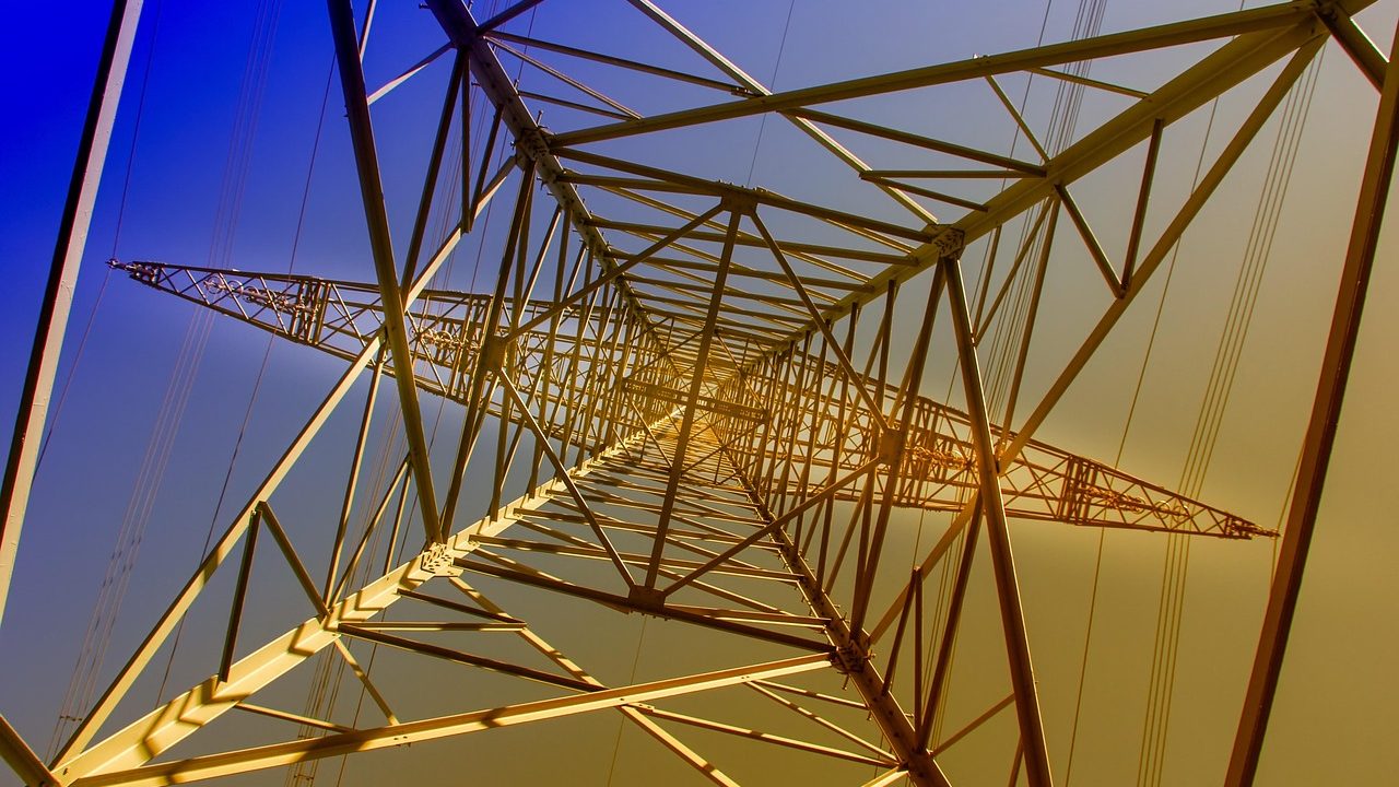High-voltage electricity transmission towers and power lines stretching across open countryside.