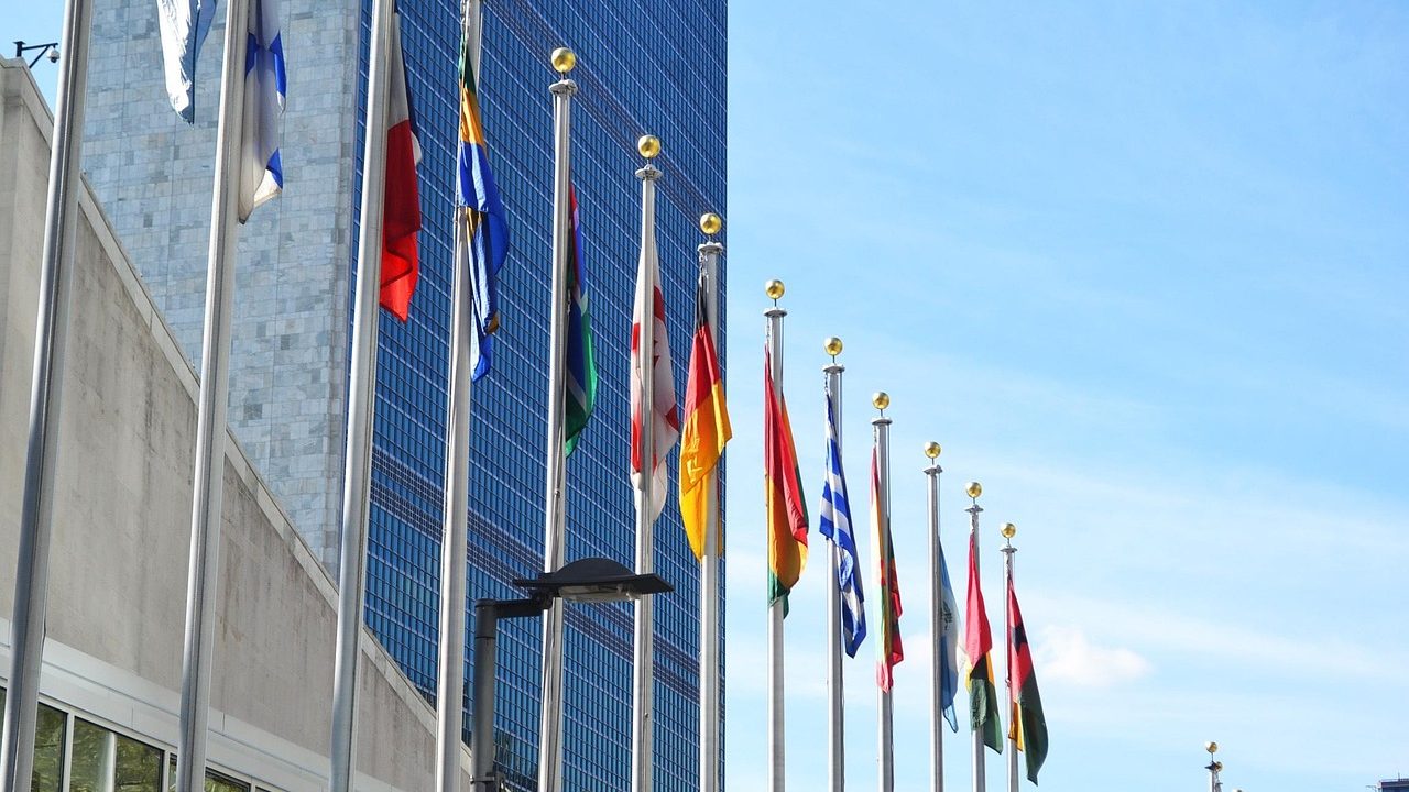 The United Nations Security Council chamber with curved table and country nameplates.