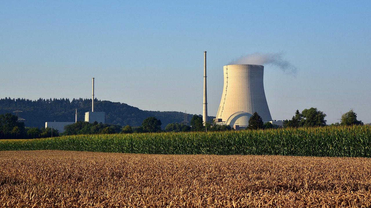 Large concrete cooling towers at a nuclear power plant under an overcast sky.
