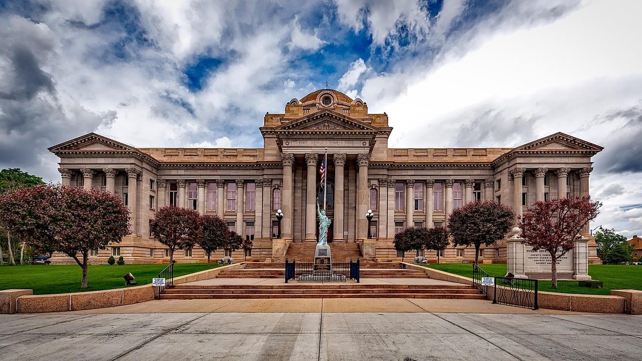 Stone columns at the entrance of a federal courthouse photographed from below.