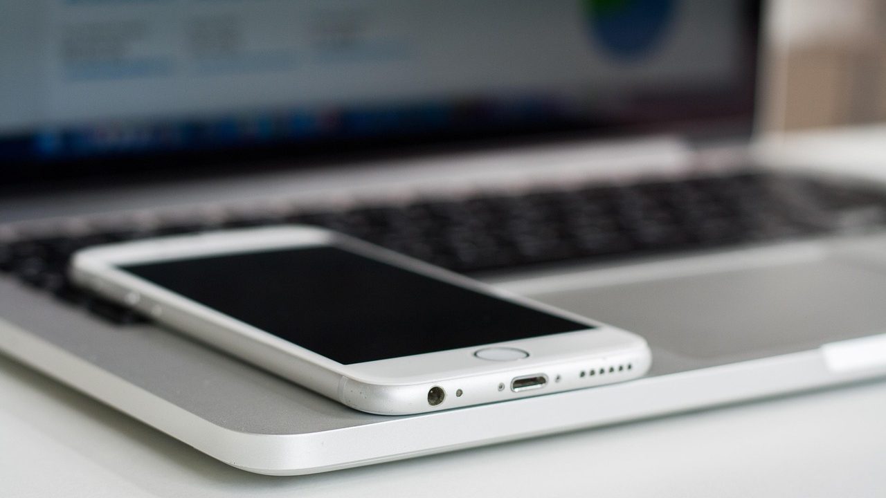 A close-up of a smartphone screen glowing with app icons in soft light.