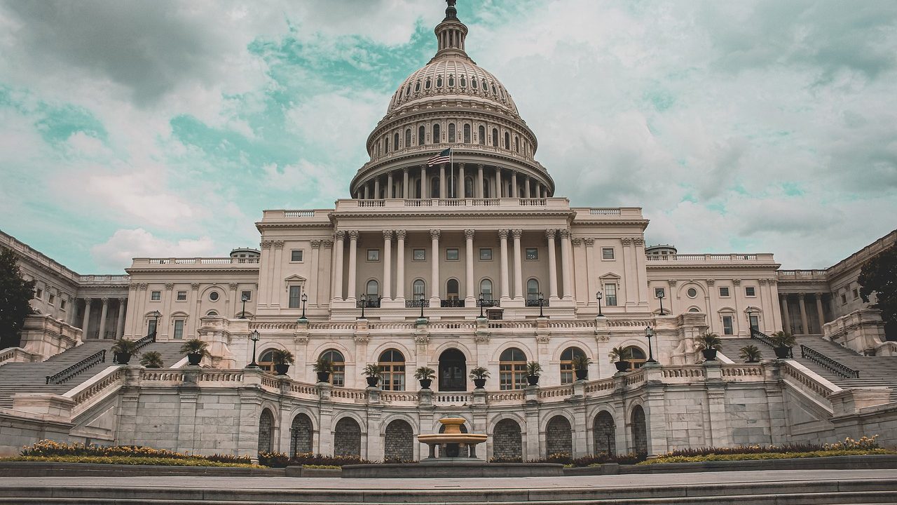 The U.S. Capitol building glows at dawn with a clear sky overhead.