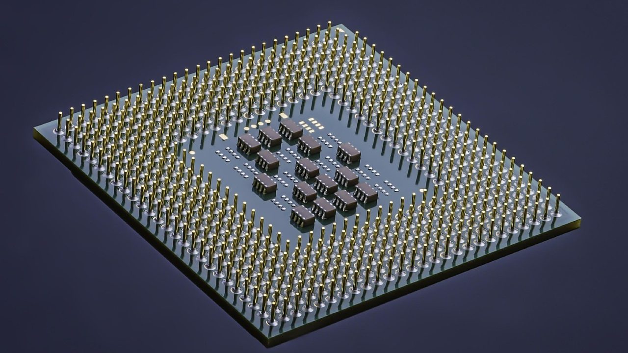 Extreme close-up of a semiconductor microchip showing intricate gold circuit pathways.