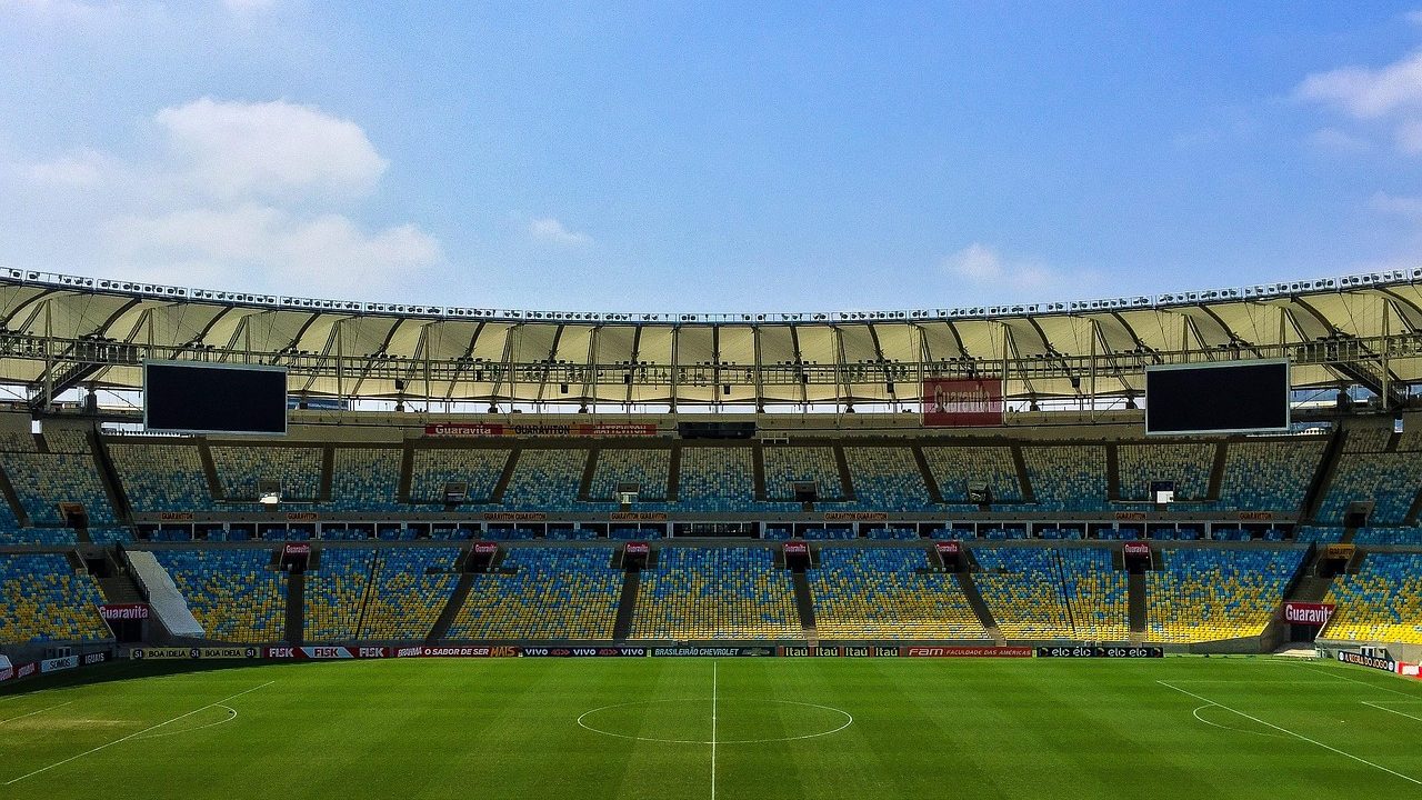 A large soccer stadium filled with spectators during a nighttime closing ceremony with colorful lighting.