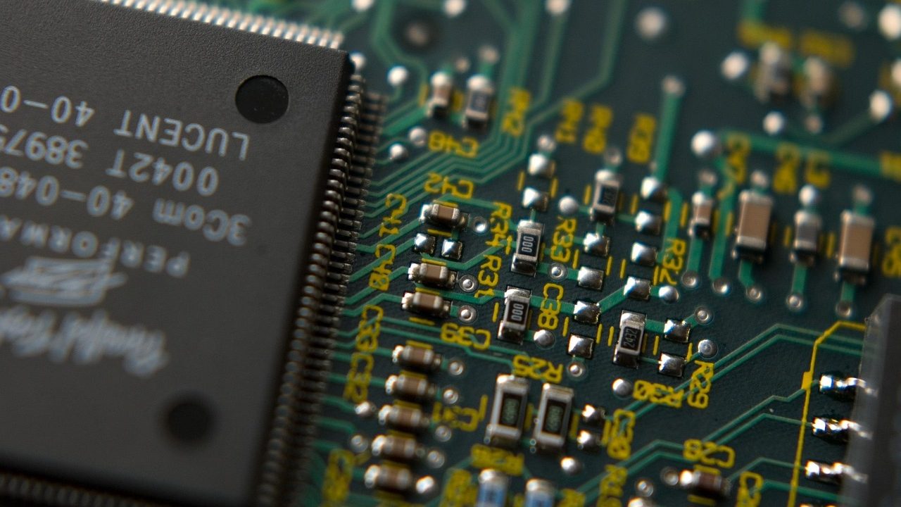 A silicon wafer covered in integrated circuit patterns under clean-room lighting.