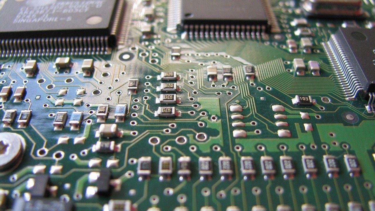 A close-up of a green circuit board with microchips and electronic components.