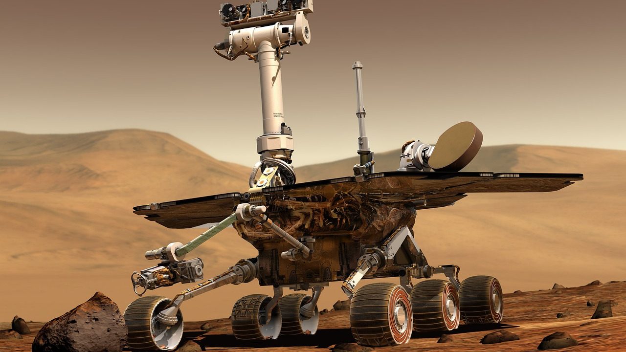 A vast, barren reddish rocky landscape stretching to a flat horizon under a hazy sky.