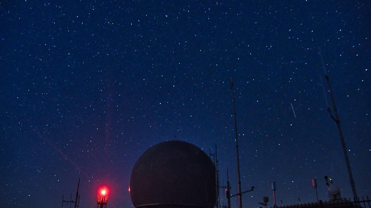 A large astronomical observatory dome silhouetted against a star-filled night sky.