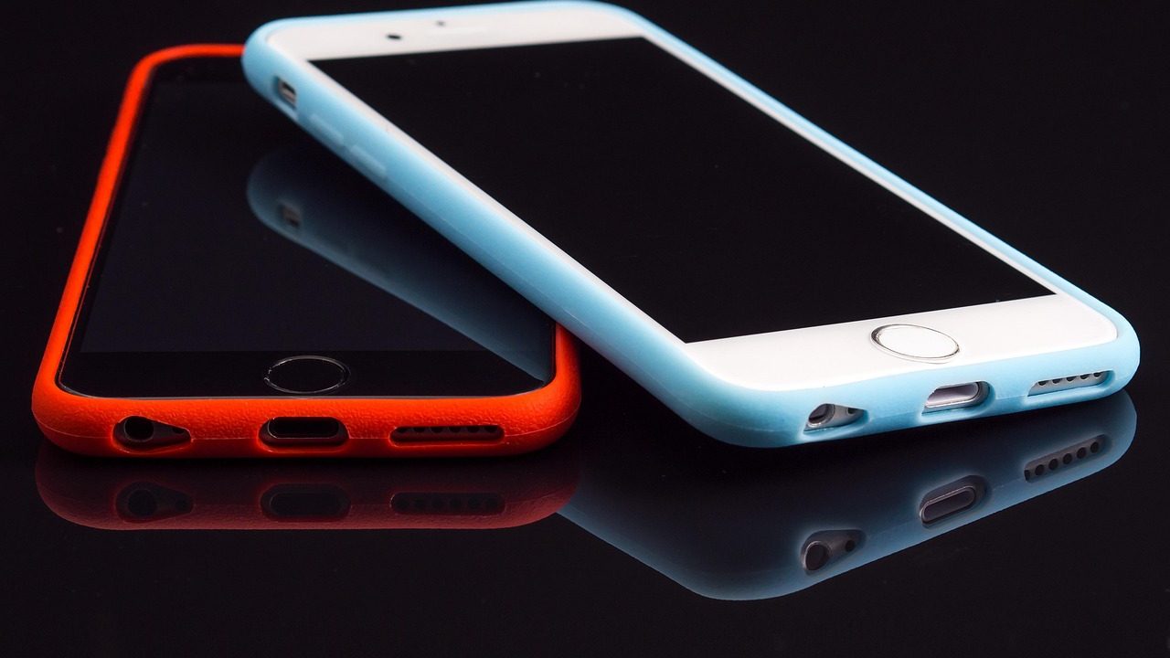 A hand holds a smartphone displaying a glowing screen against a blurred background.