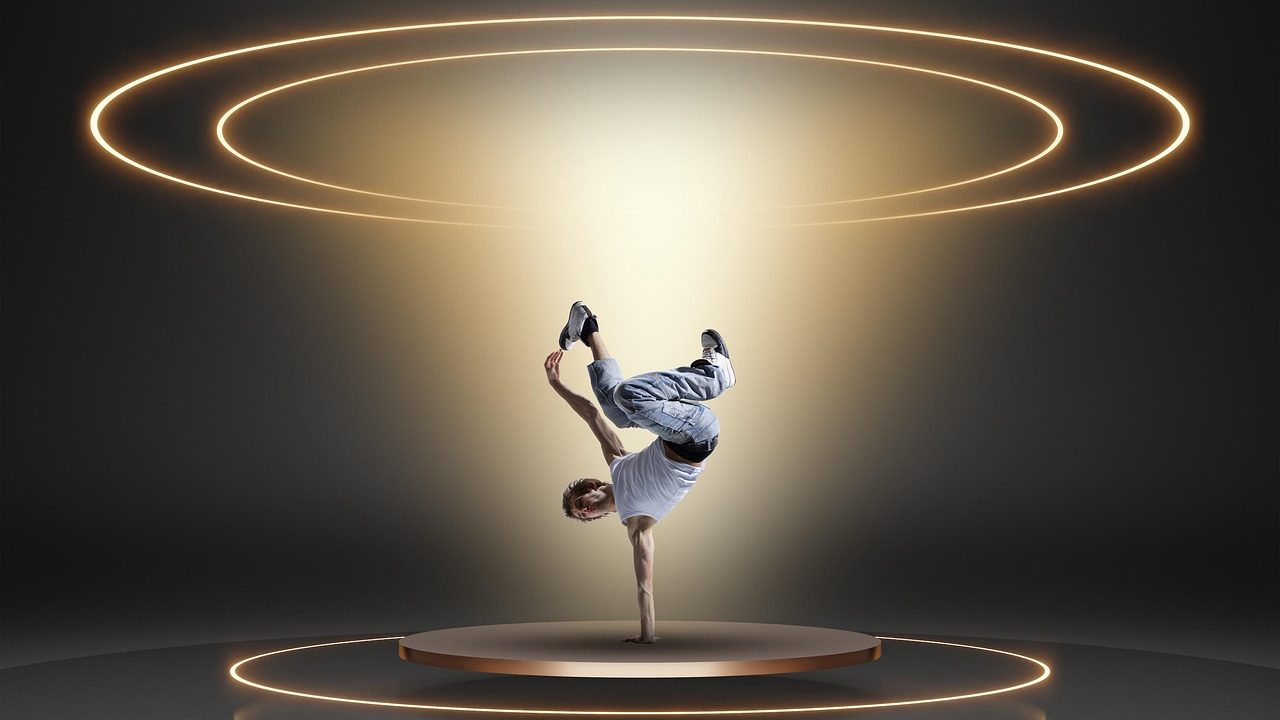 A breakdancer performing a freeze move on a polished stage floor under stage lighting.