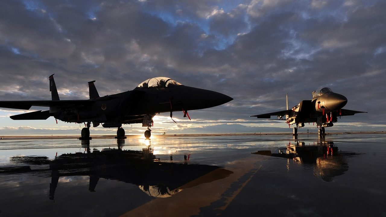 A military fighter jet parked on a runway under an overcast sky.