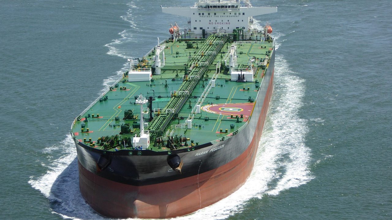A large oil tanker navigates open ocean waters under a cloudy sky.
