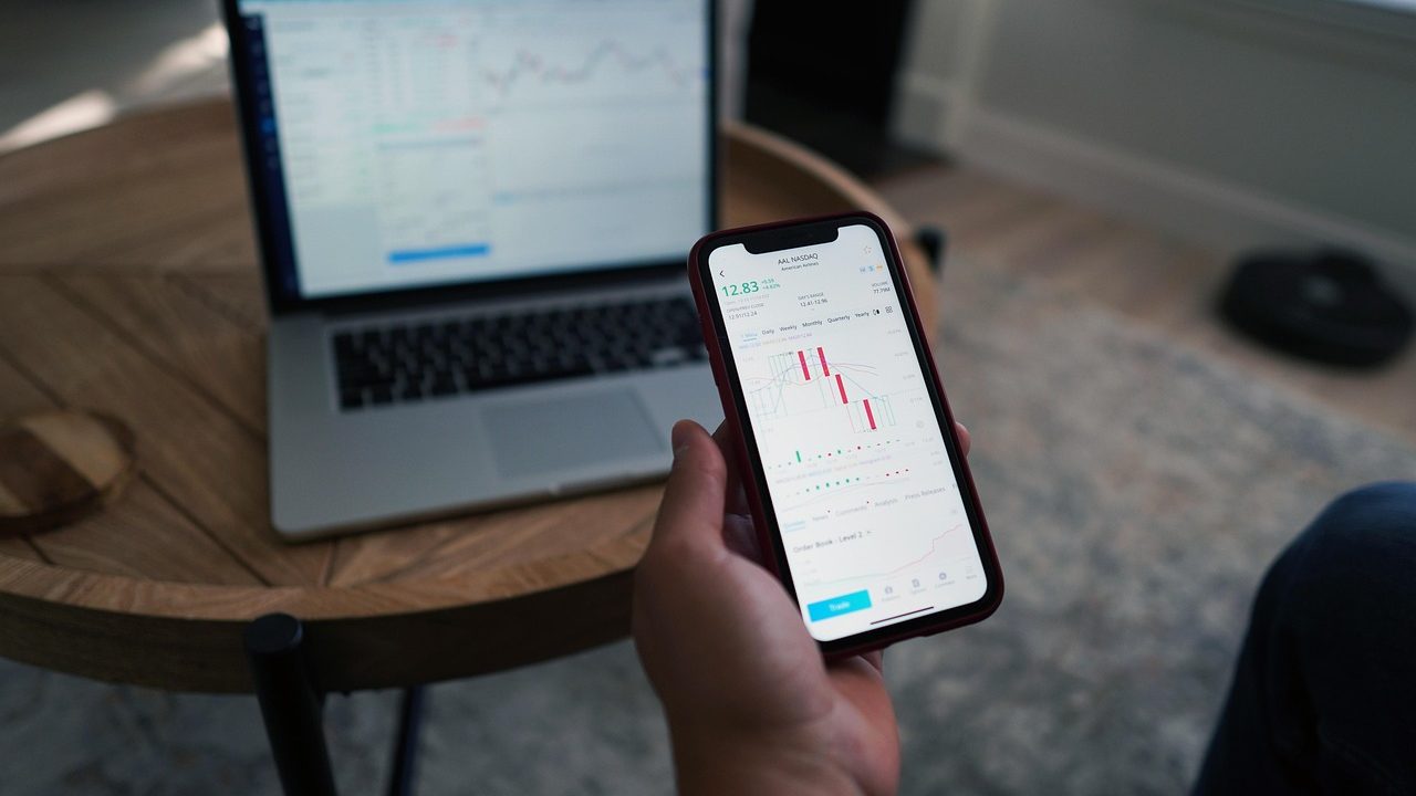 Traders at desks surrounded by multiple monitors displaying financial data on an exchange floor.