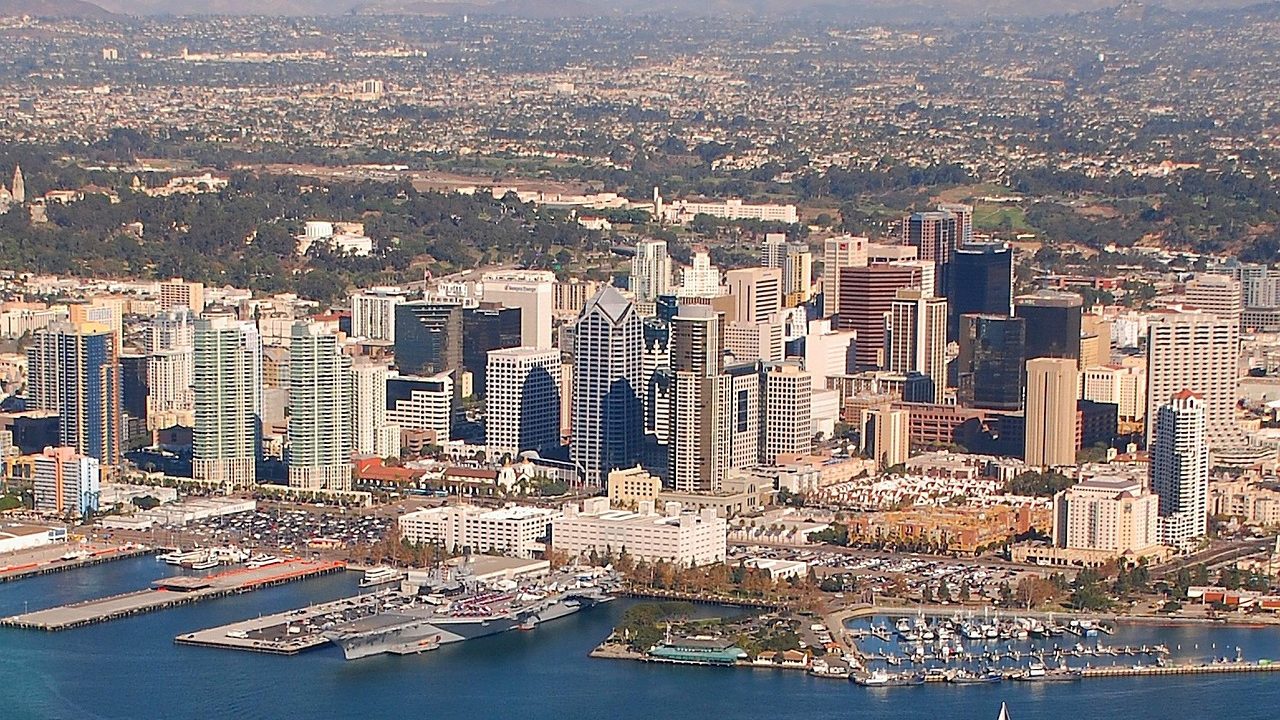 A wide view of the San Diego city skyline on a hazy summer day.