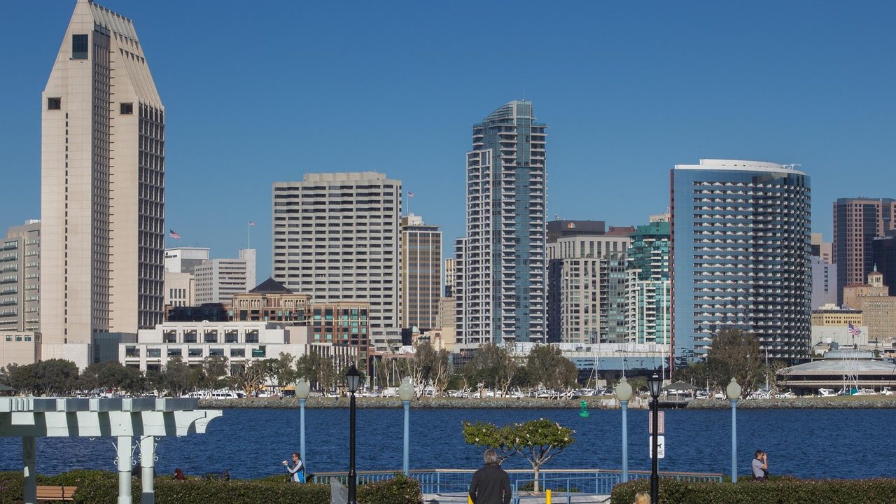 Calm waters of San Diego Bay at dawn with distant city skyline.