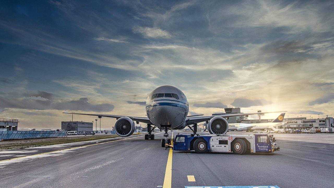 Commercial jet aircraft parked at a terminal gate with jetway attached.
