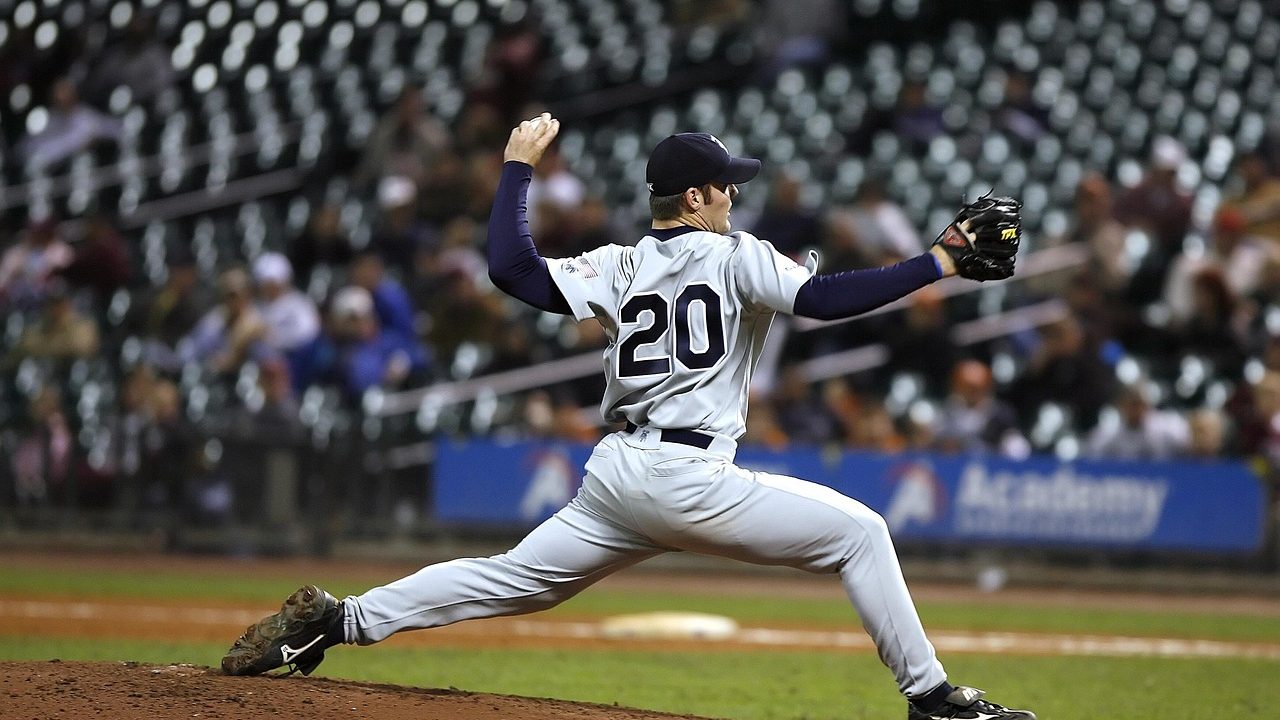 A pitcher winds up on a major league baseball mound in a packed stadium.