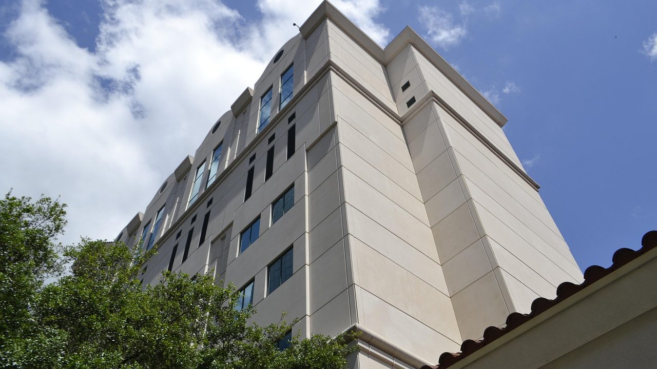 The glass and concrete exterior of a modern hospital building on a clear day.