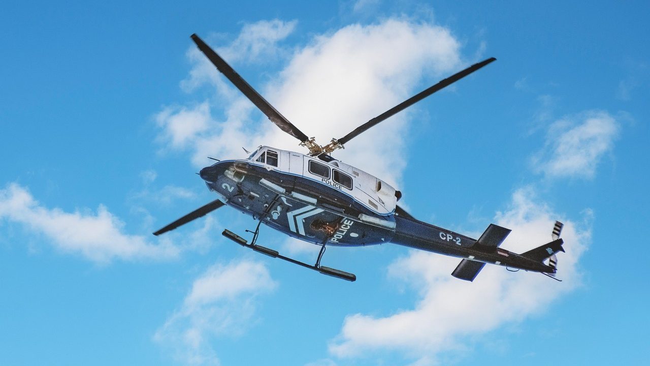 A small aircraft flies low over wetlands dispersing spray over the water.