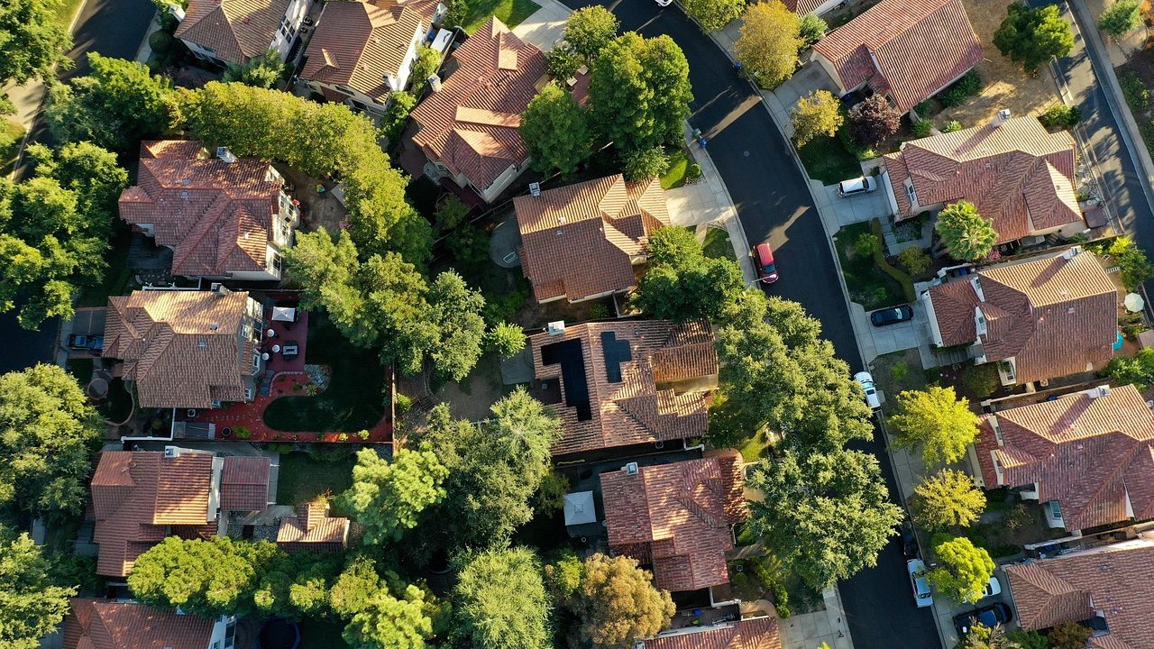 Aerial view of a dense suburban neighborhood with rows of single-family rooftops.