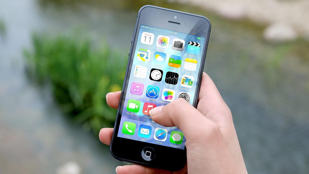 A hand holding a smartphone displaying an emergency weather alert notification.